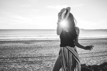 young woman with hat on beach on vacation