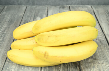 A bunch of ripe yellow bananas on the side with the handle to the wall.
