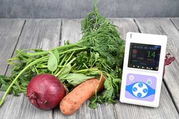 A radiation measuring device is lying next to vegetables