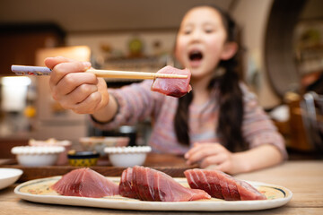 鰹の刺身を食べる子供