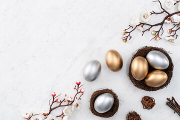Design concept of Golden and silver Easter eggs in the nest with white plum flower.