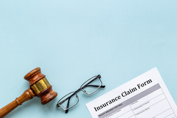 Insurance claim form with judge gavel . Top view