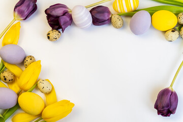 Easter composition with a  tulips and eggs on a white background. View from above. Minimal easter concept. Space for text. Easter holiday background.