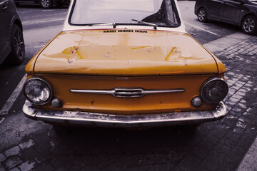 retro car auto yellow on the street of the city small funny