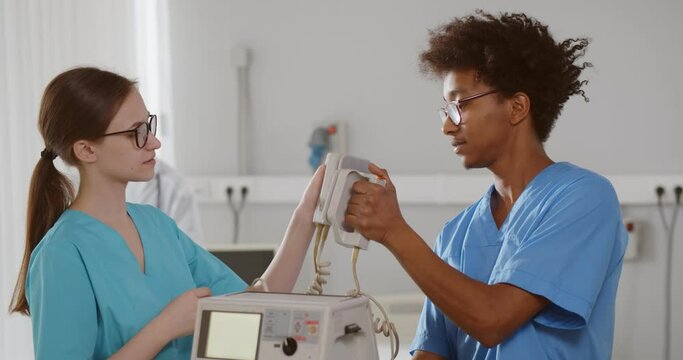 Diverse interns learning to use defibrillator for patient resuscitation