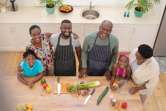 Portrait Of Happy African American Parents With Son And Daughter And Grandparents In The Kitchen