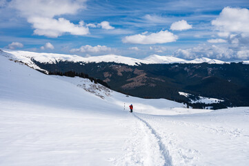 Hiker on a snowy trail in Romanian Carpathian mountains in winter