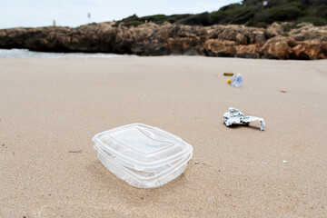 used plastic container thrown on the beach