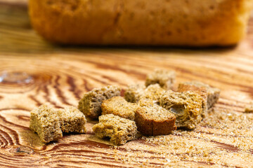 rye crackers on a wooden table in the background in a blur a loaf of bread