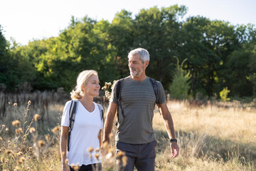 Smiling mature couple hiking in forest
