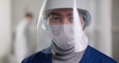 Portrait of male medical doctor wearing protective mask and face shield