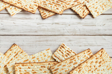 Happy Passover concept. Matzah background. Traditional Jewish regilious holiday of Pesach. Frame made of matzo bread on a white wooden table.