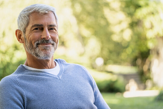 Portrait of smiling mature man in backyard