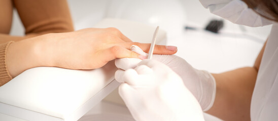 Obraz na płótnie Canvas Close up of the hand of young woman receiving the nail file procedure in a beauty salon