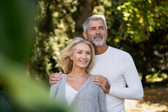 Happy mature couple standing in backyard