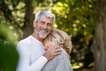 Smiling mature couple embracing each other in backyard