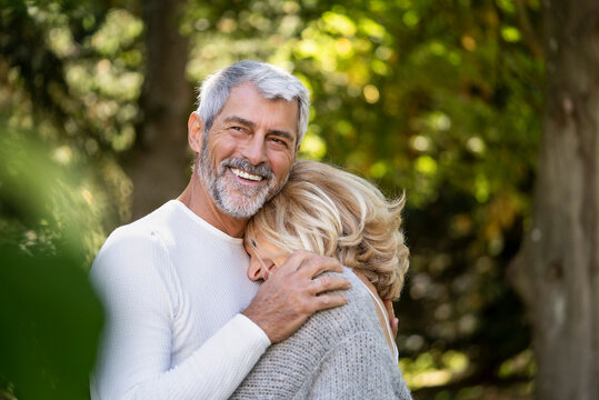 Smiling mature couple embracing each other in backyard