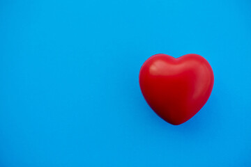 red heart on a blue background. photo with space for text.