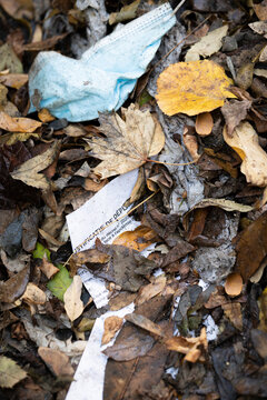 Close-up of discarded face mask lying in rubbish