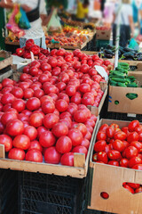 lot of ripe tomatoes are lying with other vegetables on the counter of the farmers ' market. Sale of vegetable crops at farmers ' markets