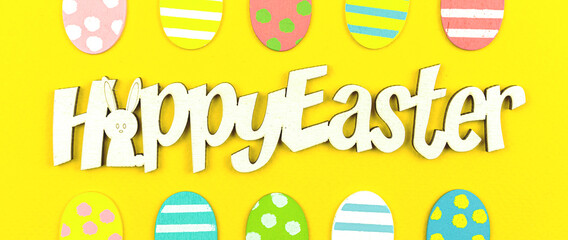 Happy Easter greeting card banner concept with text message and eater painted eggs over the yellow background