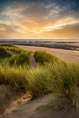 Summer evening landscape view over grassy sand dunes on beach