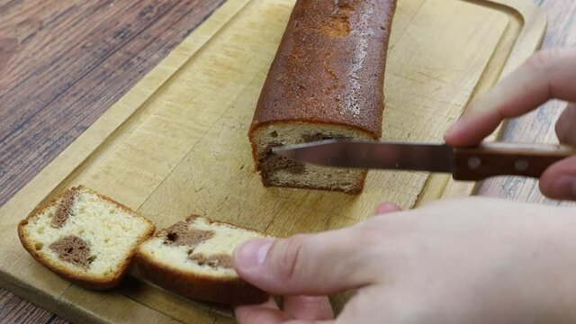 personne qui coupe marbr&eacute; au chocolat en tranches sur une planche &agrave; d&eacute;couper