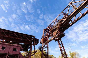 Monumental industrial architecture, metal construction on a derelict manufacturing site, bright...
