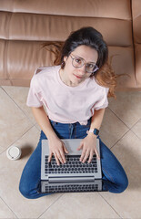 Young women using laptop while sitting on the floor at home