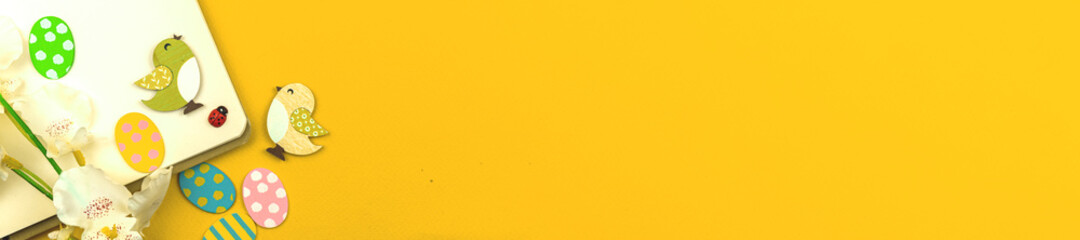 Festive easter banner, yellow background with decoration, copy space, top view