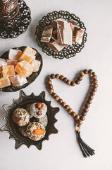 bowl with various pieces of Turkish delight locum and black tea with mint on a light background. Oriental sweets. copy space. Top view