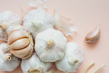 Garlic bulbs on pink background, close-up. Organic garlic top view. Food background. Selective focus.