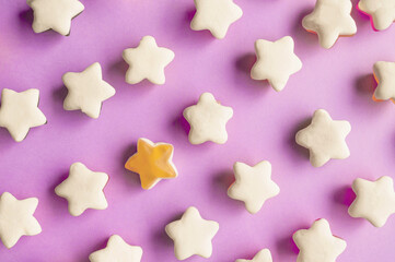 Background of jelly candies in the shape of a star. Stars of fruit marmalade on a pink solid background. Top view