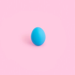 Creative minimal Easter concept with blue color egg on pastel pink background