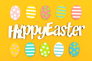 Happy Easter congratulatory background with easter eggs, text message, top view and flat lay