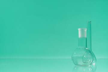 Chemical vessels. Glass flasks. Laboratory utensil. Green background.