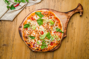 Italian pizza Margherita with greens on wooden table