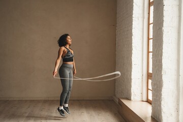 Woman is jumping rope, workout at health club. Sporty attractive female working out. Healthy lifestyle