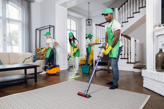 Group of four multiracial people cleaning client house