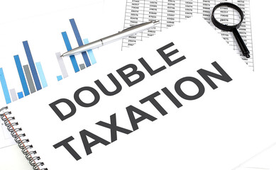 In the notebook, the text DOUBLE TAXATION , next to magnifier and a pen, the background is graphics.
