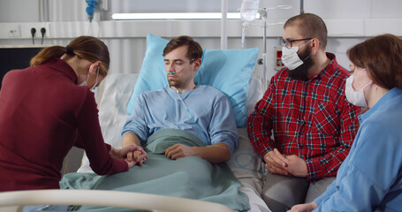 Friends come to visit the sick male patient in hospital
