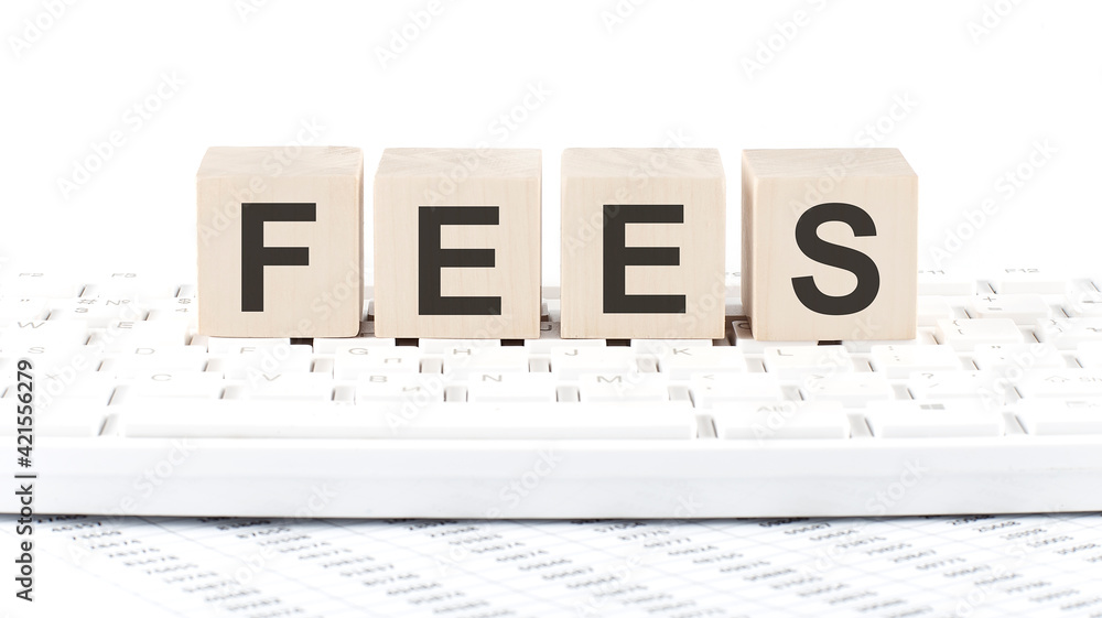 Aufkleber fees -word wooden block on keyboard background witn chart