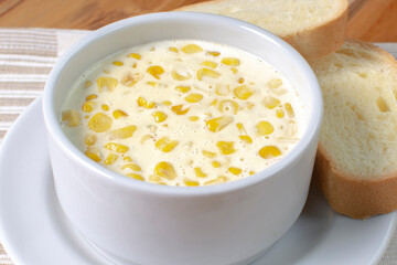 Corn flakes with gratin cheese, accompanied by bread on wooden background