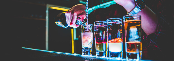 bartender making collection of colorful shots. Set of cocktails at the bar