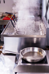 Boiling handmade pasta. Italian spaghetti boiling. Clean kitchen. Concept fast food restaurant equipment. Industrial kitchen. Electric machine boiling water. Steam in the kitchen. Clean kitchen steam.