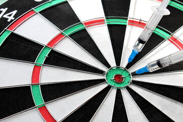 In the game of darts, the target in the middle is the vaccine in the syringe
