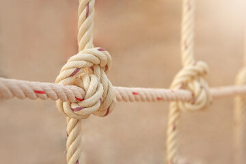 White rope tied in a netting knot for playground adventure.