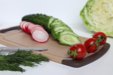 Preparation of a salad of radishes, cucumbers and cabbage.