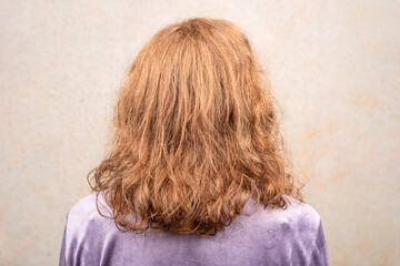 Woman with beautifully dyed hair with her back to the camera.