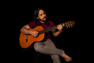 Man playing guitar with black background